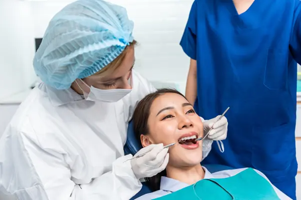 A dentist at Clementi examining a patient's mouth to diagnose the cause of bad breath