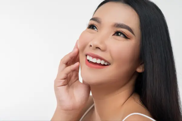 A happy woman admiring her bright, white smile after a successful teeth whitening treatment