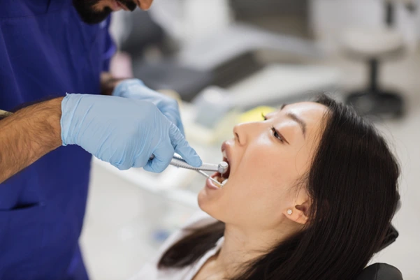 A dentist at Clementi performing a tooth extraction procedure