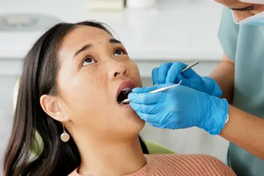 A patient receiving dental examination for tooth extraction