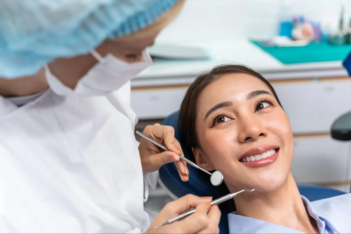 Patient smiling during a dental check-up examination at a dental clinic.