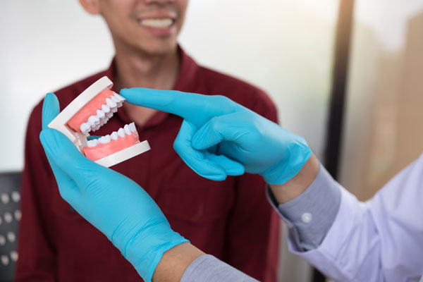 dr. Tan Boon Eng Showing Tooth to Patient dr. Tan Boon Eng Showing Tooth to Patient